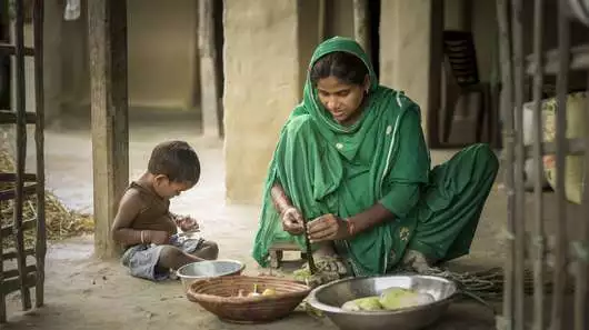 Eine Mutter bereitet mit ihrem Kind Gemüse zu. Nepal 2022.