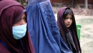 Frauen und ein junges Mädchen bei einer Lebensmittelverteilung in Kabul. 