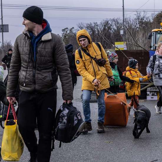 Jetzt für die Ukraine spenden. Mehrere Menschen mit Koffern und Taschen gehen auf die Kamera zu.