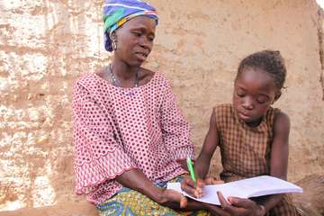 Mutter lernt mit ihrer Tochter lesen und schreiben
