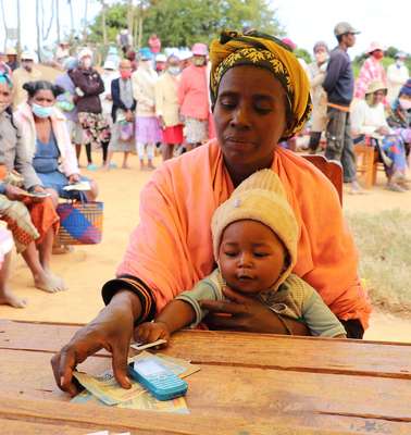 Eine Frau und ihr Baby beim Cash Transfer in Madagaskar. Anticipatory Action bedeutet auch, von Notlagen gefährdete Menschen zu ermöglichen, für sich selbst sorgen zu können.