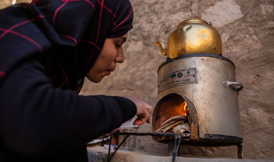 Jetzt für Afghanistan spenden - Bild: Eine Frau in Afghanistan beim Gebrauch eines energiesparenden Herds