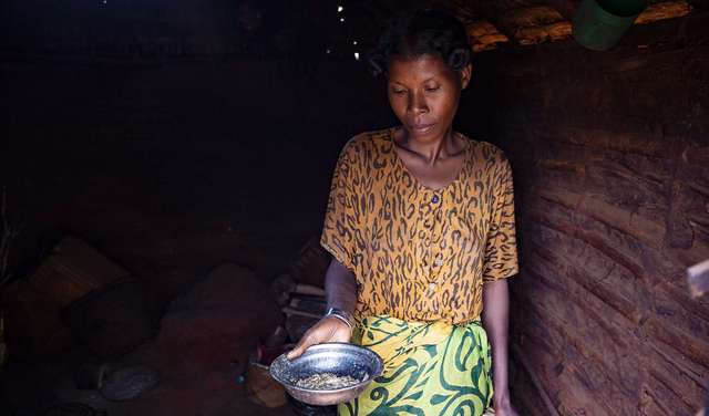 Eine Frau zeigt eine fast leere Metallschüssel, Madagaskar 2021.