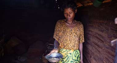 Eine Frau zeigt eine fast leere Metallschüssel, Madagaskar 2021.