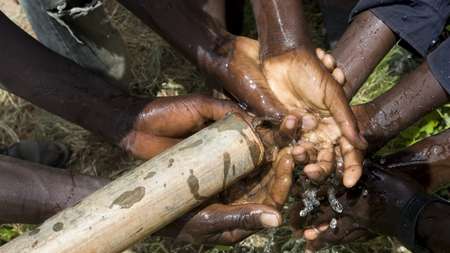 Kinder waschen sich am Brunnen die Hände in Nkayi, Region Matabeleland, in Simbabwe.
