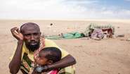 Ein erschöpfter Mann mit Kind während einer Dürre in Somaliland. 