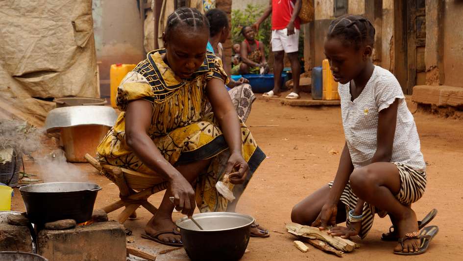 Eine Familie kocht ein einfaches Essen in Bangui, 2018. 