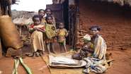 Eine Familie sitzt vor ihrer Hütte, Madagaskar 2021
