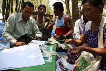 Fünf Myanmare sitzen zusammen und zählen Geld