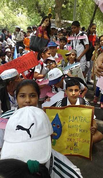 Ein Junger Demonstrant hält einen Banner in der Hand mit der Aufschrift: Water, water, everywhere, try to safe.