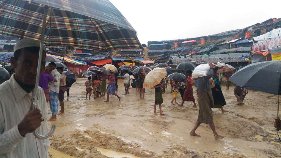 Menschen mit Regenschirmen im Flüchtlinglager Cox's Bazar