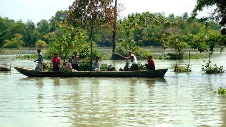 Flut in Indien: Männer überqueren die Fluten im Boot