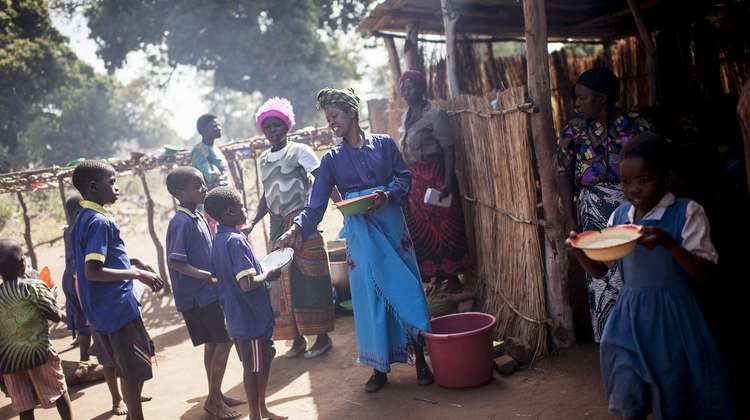 In der Yambe Grundschule, Malawi, verteilen Frauen Essen an die Kinder.