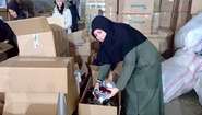 Eine Frau packt Kartons mit Hilfsgütern aus.