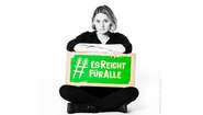 Schauspielerin und Regisserin Julia Becker hält ein Schild mit dem Welthungerhilfe-Hashtag #EsReichtFürAlle.
