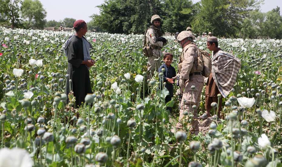 US-Soldaten grüßen Kinder in einem Mohnfeld in Afghanistan im Jahr 2011. 