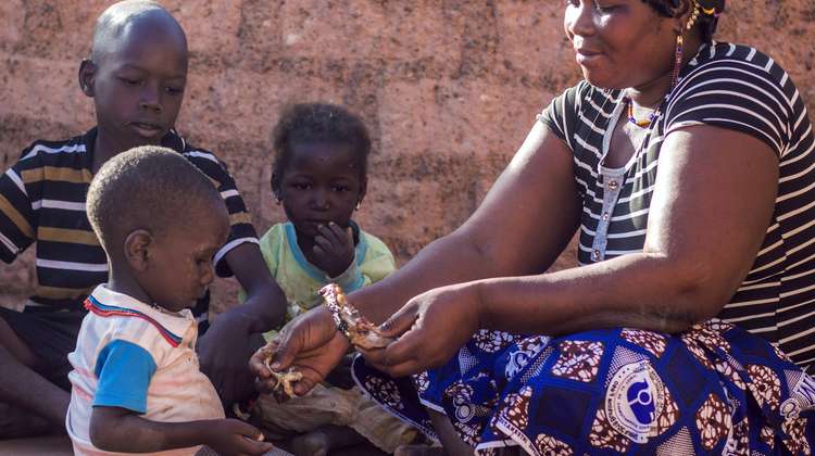 Eine Frau füttert ihr Kind. Durch den Preisanstieg von Lebensmitteln gibt es nicht mehr genug zu essen.