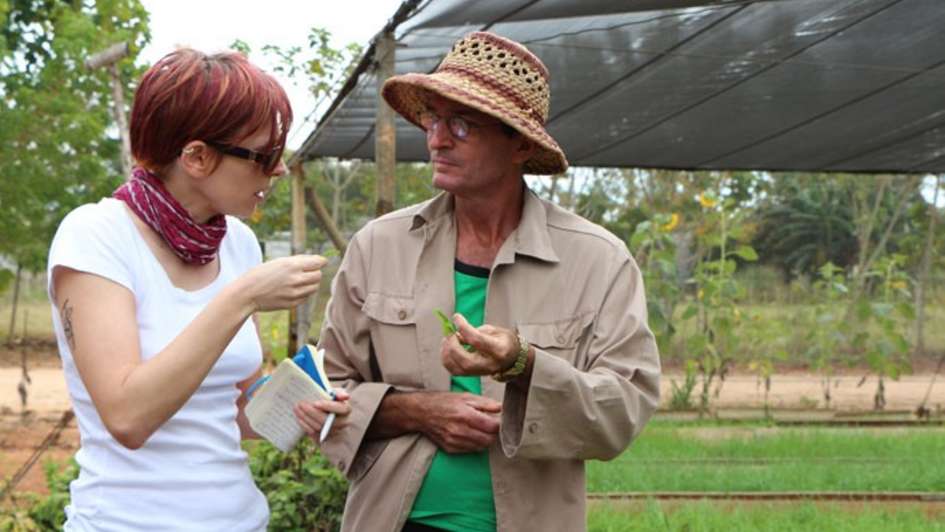 Ein Bauer zeigt Referentin Katharina Phillips seine Beete