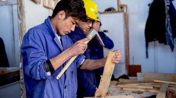 Der 18-jährige Abdul beim Bearbeiten eines Stückes Holz