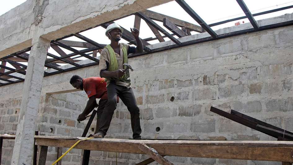 Zwei Männer auf einem Gerüst im Rohbau eines Krankenhauses in Liberia