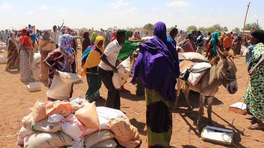 Dürre in Somaliland: Menschen warten auf trockenem Boden auf Nahrungsmittelverteilung.