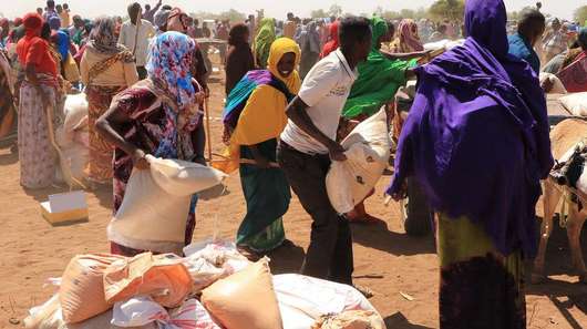 Dürre in Somaliland: Menschen warten auf trockenem Boden auf Nahrungsmittelverteilung.