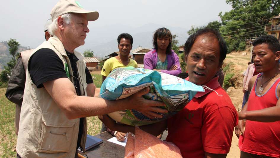 Ein Welthungerhilfemitarbeiter verteilt Linsen an bedürftige Nepalesen