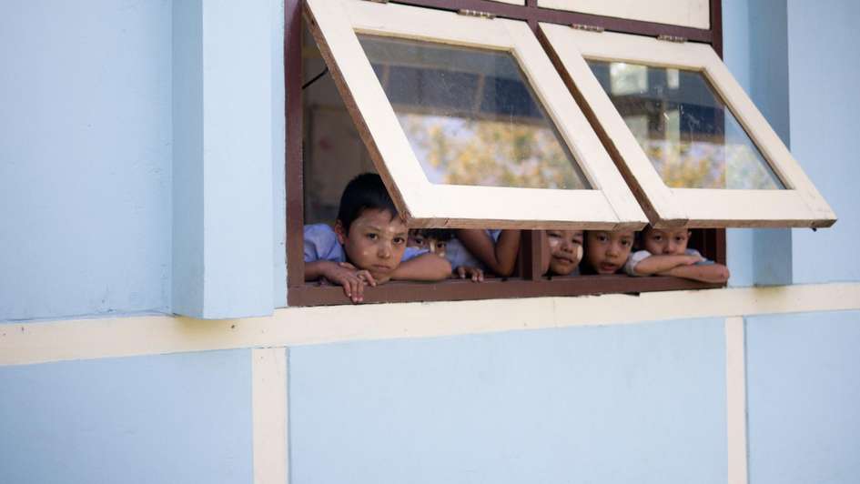 Schulkinder schauen aus dem Fenster.