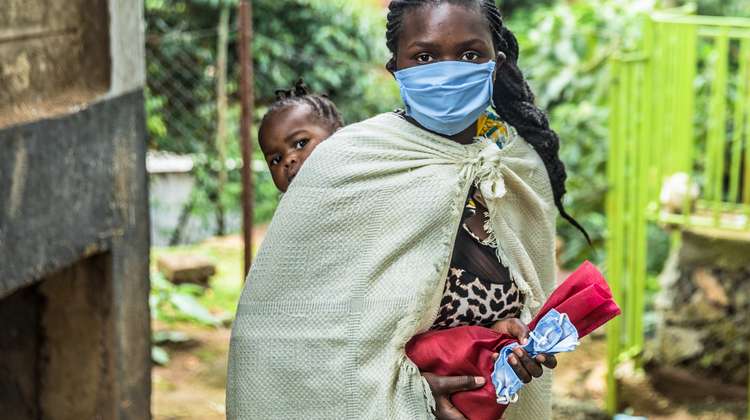 Eine Mutter mit ihrem Kind bei der Lebensmittelverteilung, Nairobi.