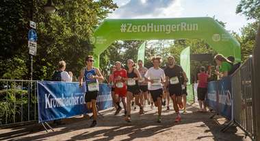 Läufer unter einem aufblasbaren Torbogen mit Aufschrift #ZeroHungerRun
