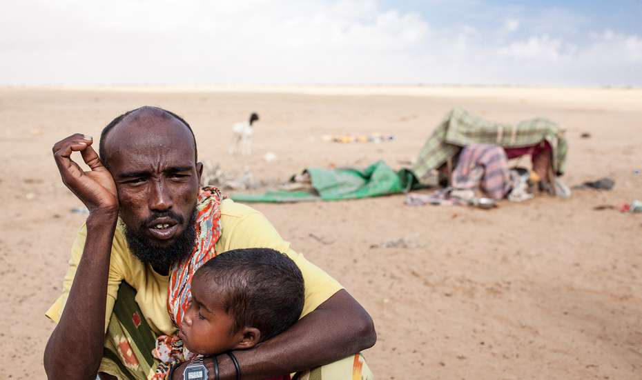 Ein erschöpfter Mann mit seinem Kind in der Dürre in der Lughaya Region in Somaliland.