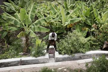 Ein Mann öffnet den Wasserlauf einer Bewässerungsanlage in Haiti.