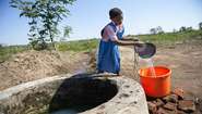 Chimwemwe holt Wasser am neu gebauten Brunnen der Schule
