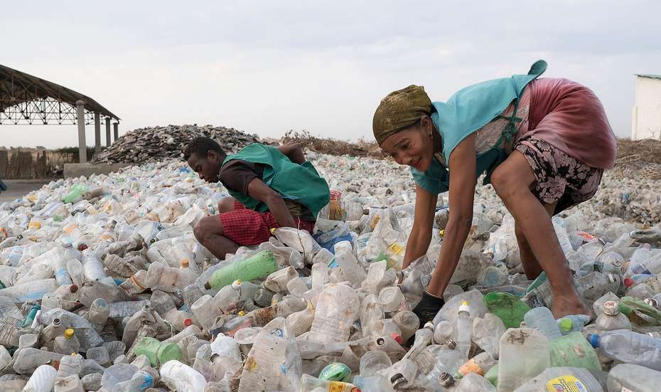 WASH-Projekt in Madagaskar: Zwei Personen stehen in einem Meer aus Plastik.