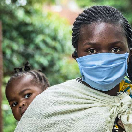 Coronavirus in Afrika. Bild: Eine Frau mit Mundschutz un einem Kind auf dem Arm.