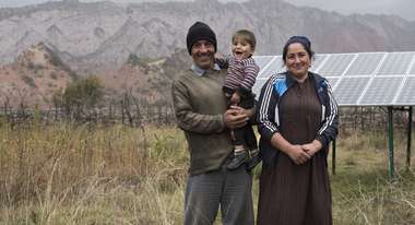 Eine Familie steht vor einer Solaranlage.