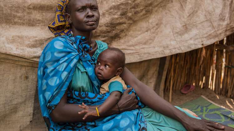Jetzt spenden für Menschen im Südsudan. Bildbeschreibung: Eine Frau mit ihrem Kleinkind in Ganyiel, Südsudan.
