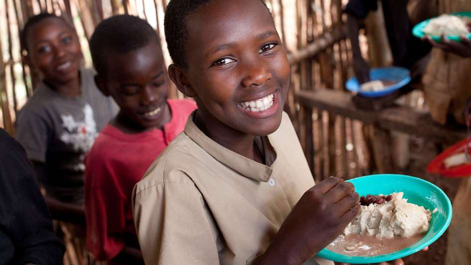 Schulkind in Burundi bekommt Nahrung
