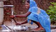 Ein Mädchen wäscht an einem Brunnen, Indien, 2008.