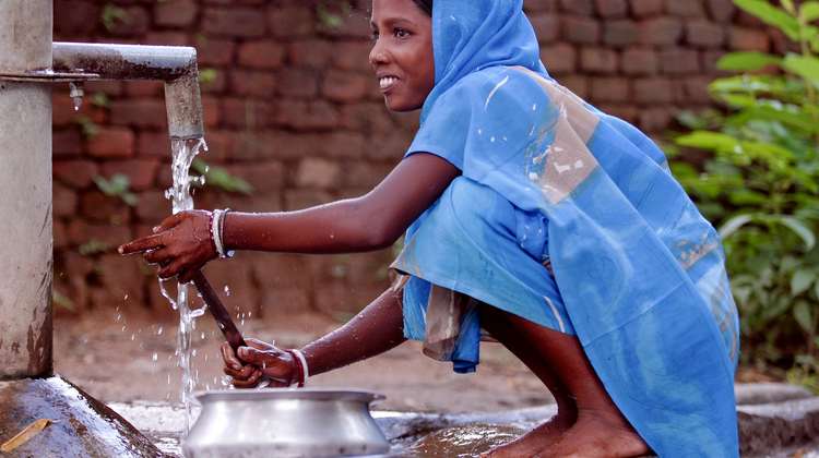 Ein Mädchen wäscht an einem Brunnen, Indien, 2008.