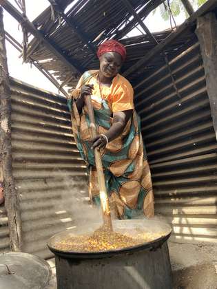 Eine Frau kocht einen großen Topf voll Essen, Südsudan 2022.