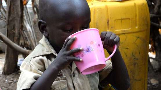 Ein Kind in Kenia trinkt aus einem Becher, 2020. 