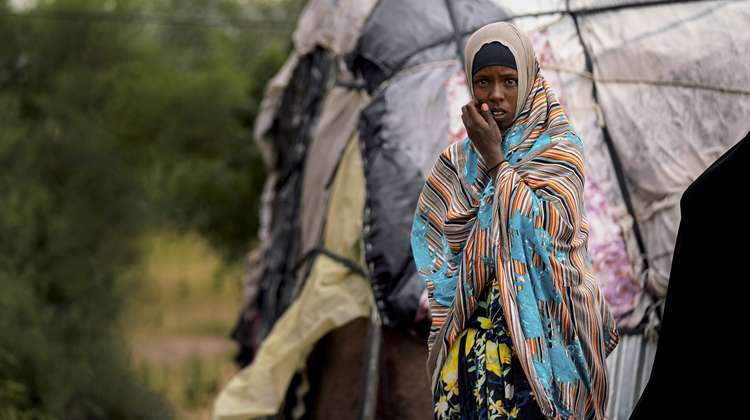 Eine Frau in Somaliland steht vor ihrem Zelt, 2020. 
