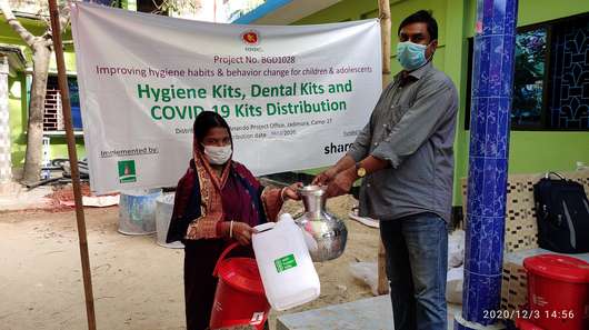Eine Frau bekommt ein Hygiene-Paket für den Schutz gegen Corona, Bangaldesch 2021.