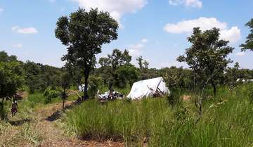 Ein Zelt einer Familie inmitten einer Grünflache.