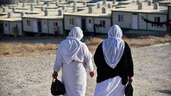 Jesidische Frauen gehen nebeneinander her zum Flüchtlingslager.