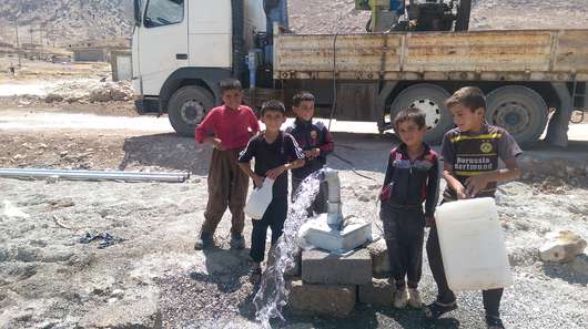 Kinder holen im Irak Wasser von einer Wassertränke.