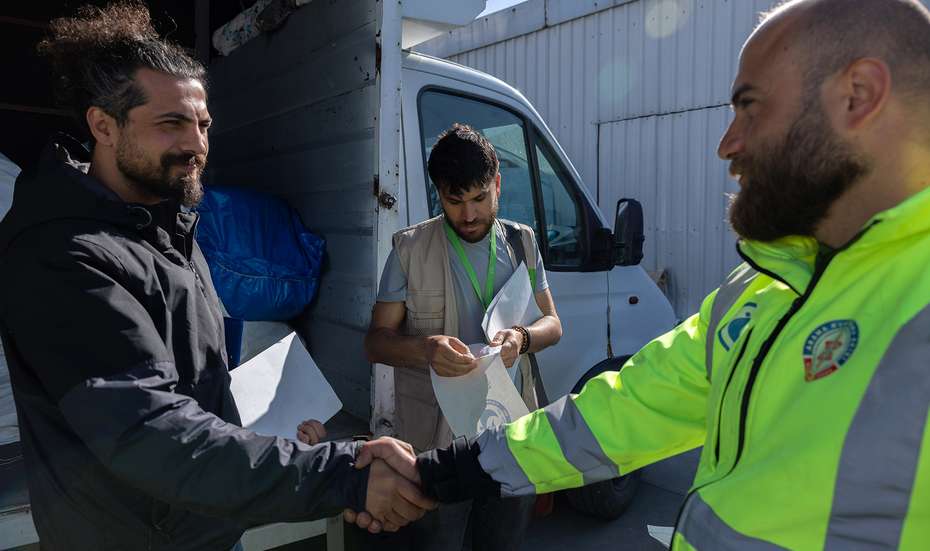 Handschlag von zwei Männern bei Verladung von Hilfsgütern in der Türkei