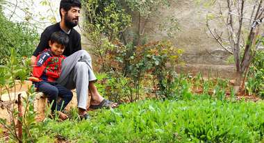 Obeida Yousef mit seinem Sohn im Gemüsegarten