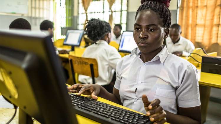 Eine junge Frau sitzt an einem Computer.